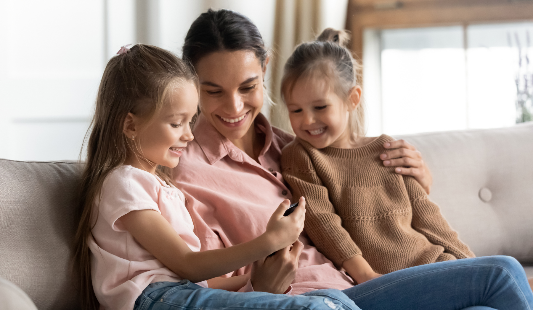 Mom and daughters looking at digital flyers on a cell phone
